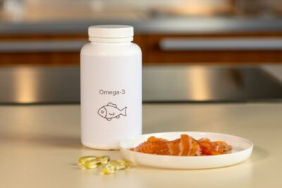 a bowl of fish next to a bottle of Omega-3