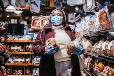 woman carrying bread while shopping in supermarket