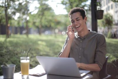 Man talking on smartphone in summer cafe