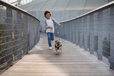 boy running on bridge with cute dog 